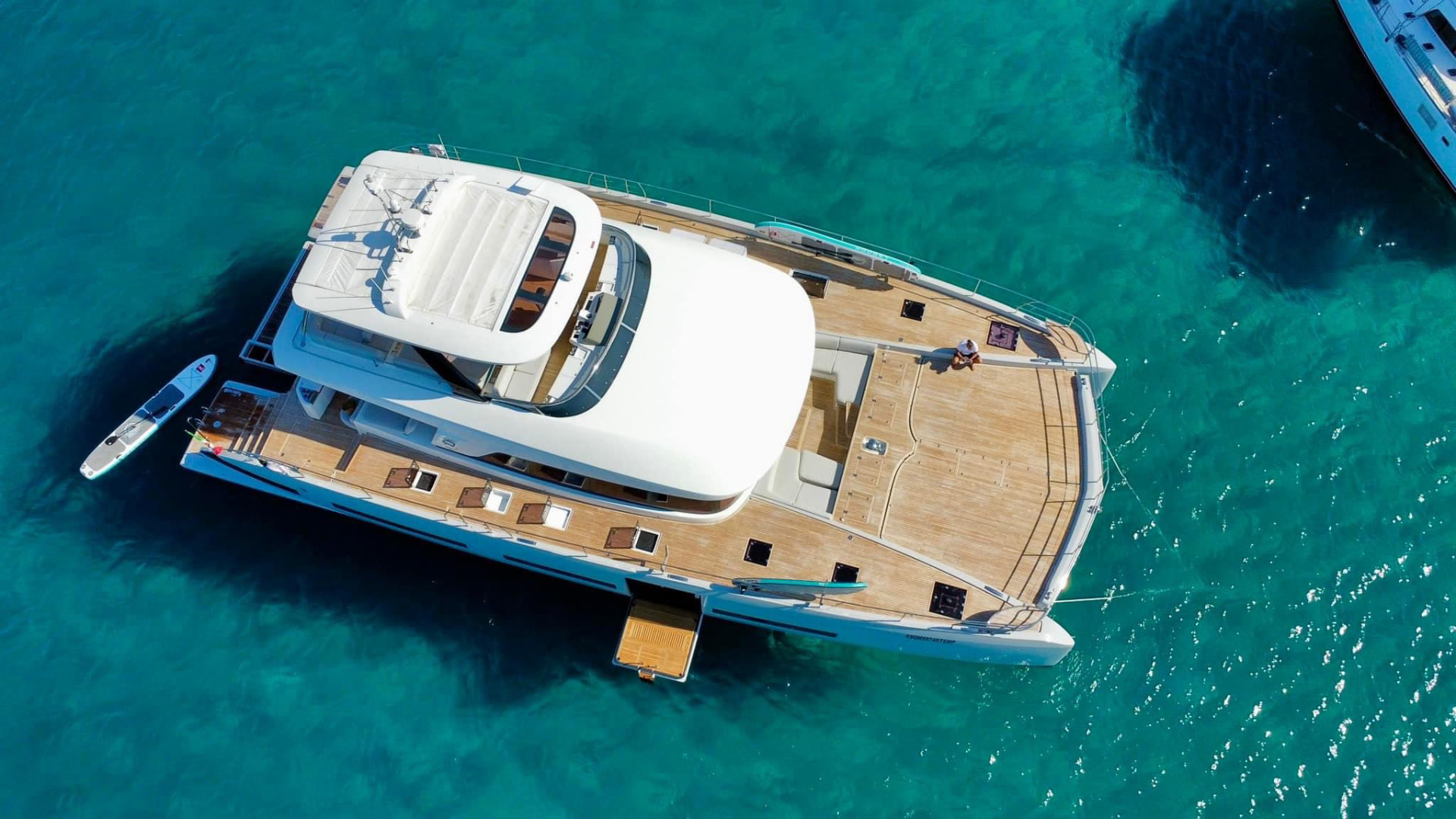 Motor catamaran viewed from above in clear Mediterranean water