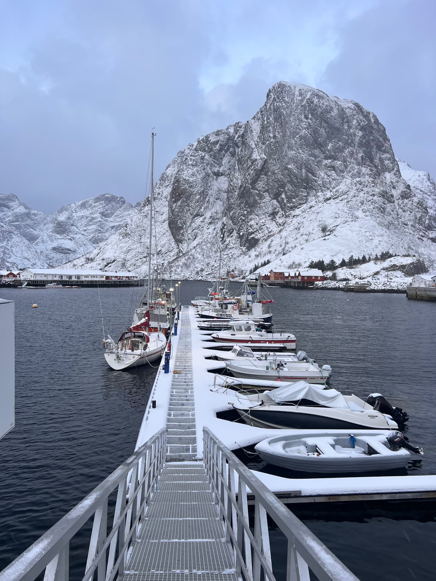 Sailing yacht and small boats in a snow-covered Norwegian harbour