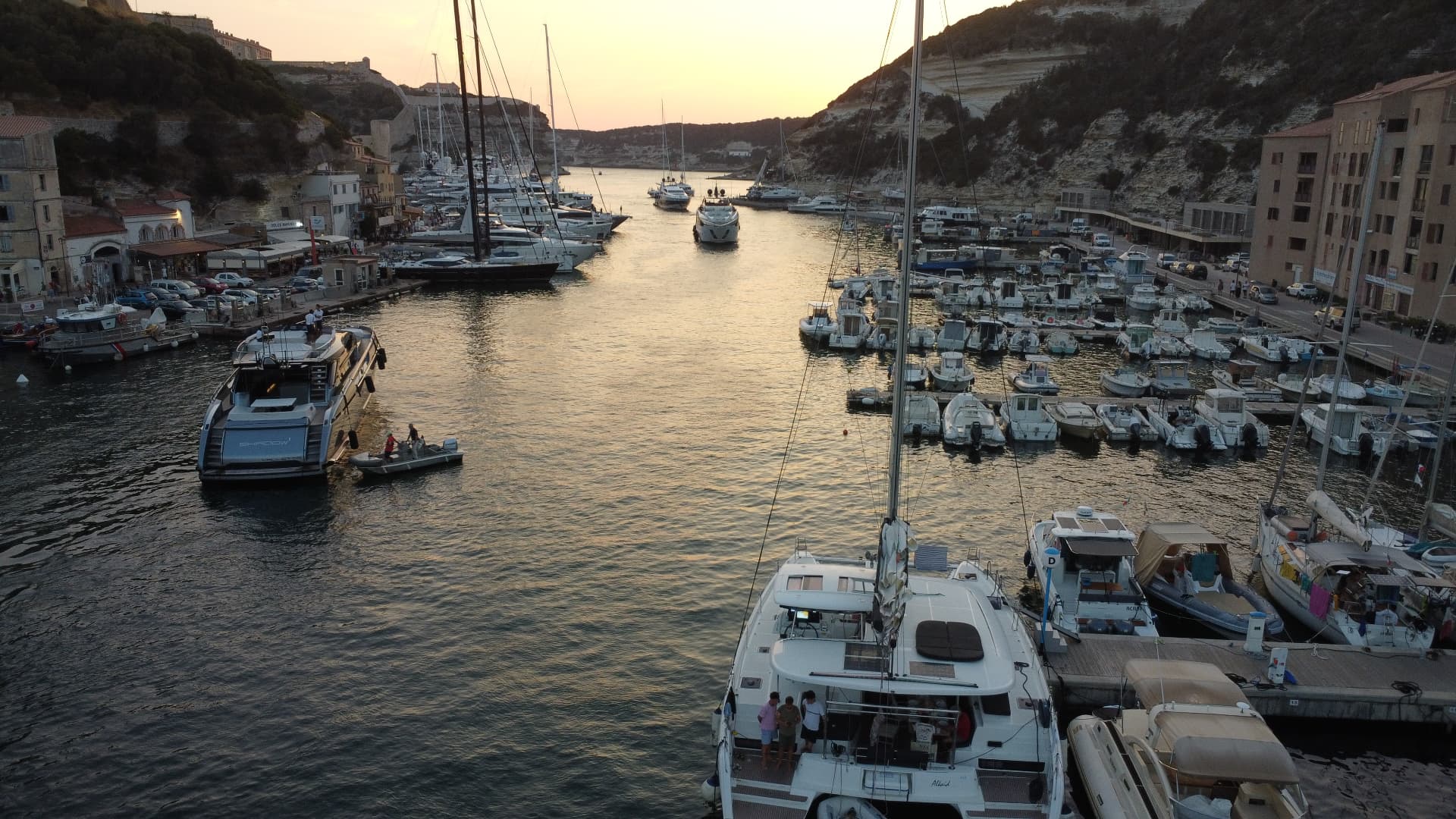 Yachts gathered in a Mediterranean marina at sunset